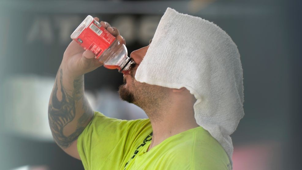 A construction worker hydrates at the Shedd Aquarium Tuesday, Aug. 27, 2024, as a second straight day of hot soupy temperatures approaching triple digits hung over much of the Midwest in Chicago. (AP Photo/Charles Rex Arbogast)